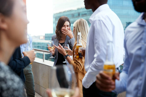 compañeros de oficina socializando con bebidas en un balcón en la ciudad después del trabajo - afterwork business fotografías e imágenes de stock