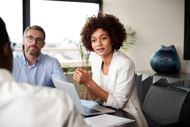 millennial black businesswoman listening to colleagues at a corporate business meeting, close up - concentration multi ethnic group meeting business imagens e fotografias de stock