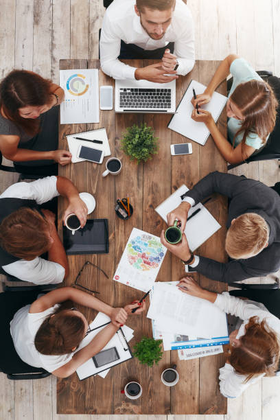 pausa de café durante la reunión de negocios. tiro vertical - desk corporate business business paper fotografías e imágenes de stock