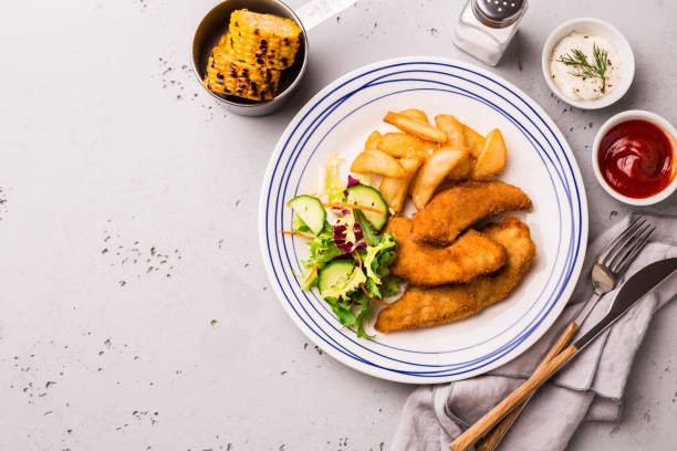 istock Lunch or dinner - chicken strips, fries, salad, corn and dips 1146475912