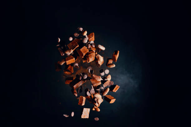 explosión de alimentos de chocolate con cacao en polvo, chips de chocolate y nueces - high speed flash fotografías e imágenes de stock
