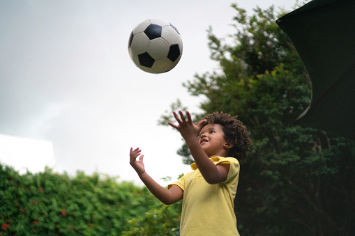 Young boy throwing a soccer ball to the air
