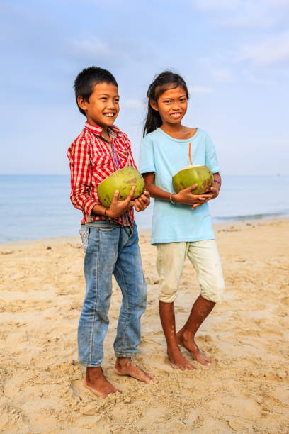 istock Cambodian children holding coconuts on the beach, Cambodia 1146480039