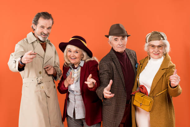 istock cheerful senior people smiling and gesturing isolated on orange 1146481233