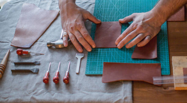 istock Craft man is working on his leather craft, making vintage leather bag by leather work tool. 1146484939