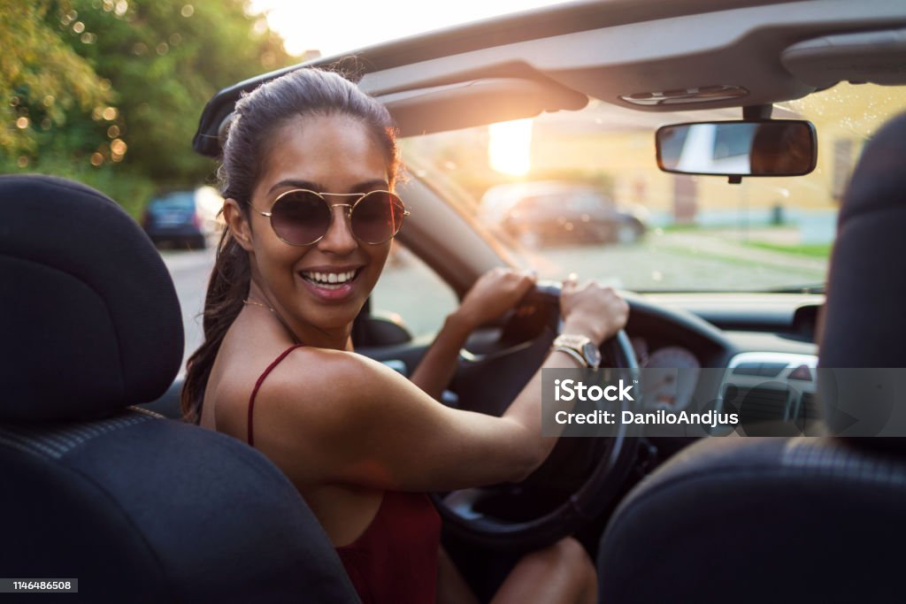 its time for a drive around the city young woman driving a convertible car New Stock Photo