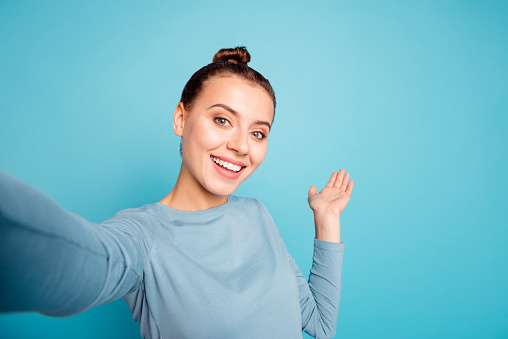 Close up photo beautiful amazing she her lady make take selfies show hand arm palm air showing way road foreigners broadcasting blog wear casual sweater pullover isolated blue bright background
