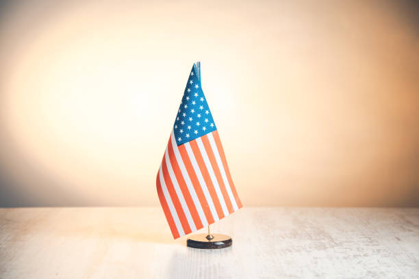 istock merican flag on desk with yellow background 1146488406