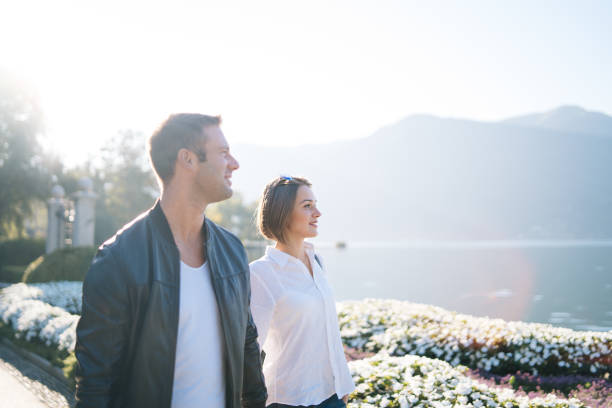 istock Couple walk along lake front promenade 1146488452