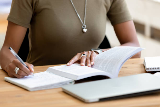 Close up african female hands holding pen make notes