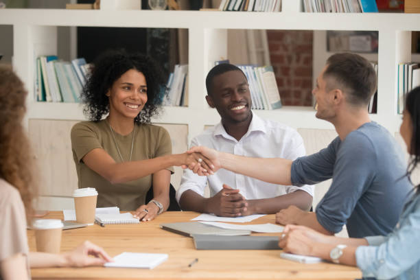 istock Diverse people starting negotiations shake hands gathered in boardroom 1146488516