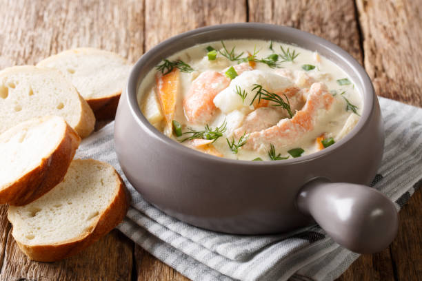 rustic style portion of fish soup with cream, carrots and celery close-up in a bowl and bread. horizontal - main course salmon meal course imagens e fotografias de stock