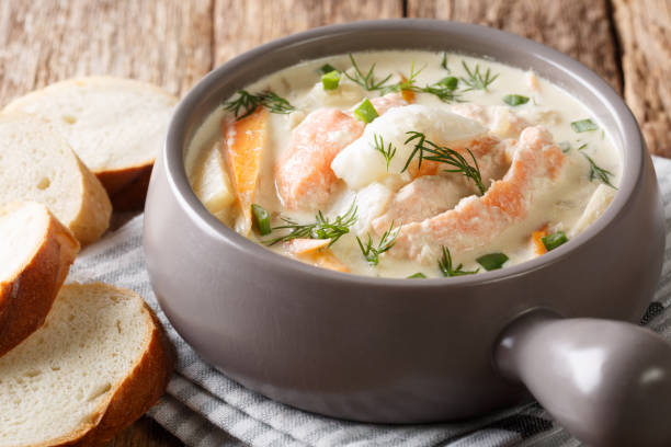 Homemade fish soup with cream, carrots and celery in a bowl close-up filed and bread. horizontal Homemade fish soup with cream, carrots and celery in a bowl close-up filed and bread on the table. horizontal Chowder stock pictures, royalty-free photos & images