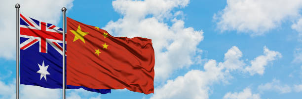 bandeira de austrália e de china que acena no vento de encontro ao céu azul nebuloso branco junto. conceito da diplomacia, relações internacionais. - ozzie - fotografias e filmes do acervo