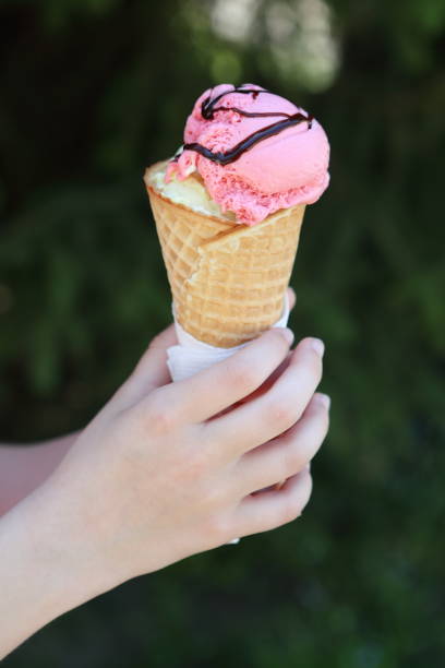 istock Horn with strawberry ice cream in children's hands 1146499856