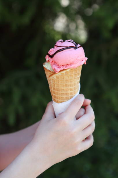 istock Horn with strawberry ice cream in children's hands 1146499867