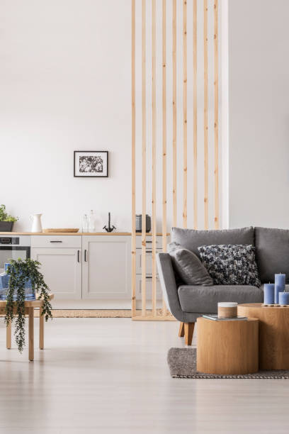 istock Open plan studio apartment with small white kitchen and living room with grey couch and wooden coffee table 1146500583