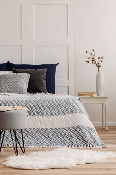 istock Open book on grey pouf in trendy bedroom interior with blue and white design 1146501577