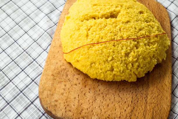 heiße dampfende polenta auf einem alten holzbrett - dishware butter cutting board agriculture stock-fotos und bilder