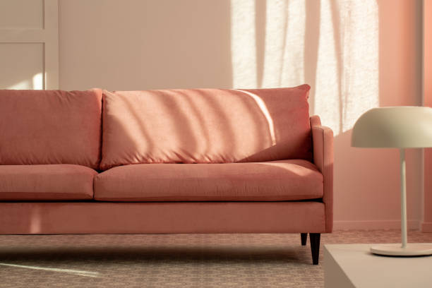 istock Pastel pink couch in white living room interior, copy space on empty wall 1146503121