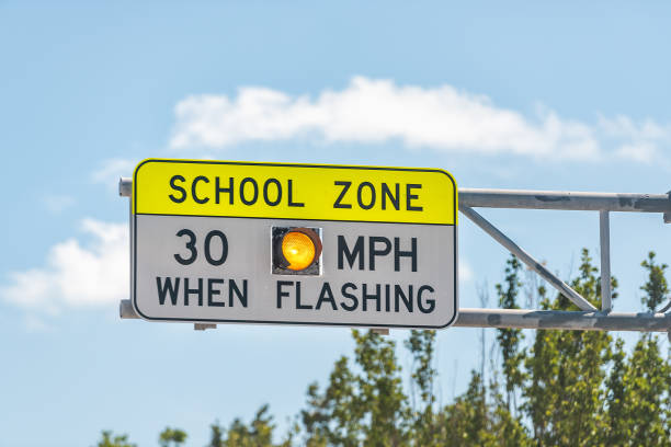 Public School Zone sign on road with 30 miles per hour when flashing text in Naples, Florida during day Public School Zone sign on road with 30 miles per hour when flashing text in Naples, Florida during day time zone stock pictures, royalty-free photos & images