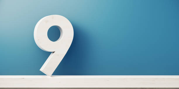 Number nine is standing in front of blue wall. Horizontal composition with copy space.