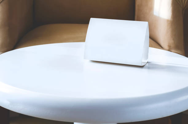 istock White sign cardboard with copy space on a white round table. Hotel interior 1146518302
