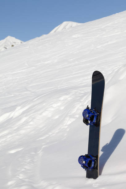 istock Snowboard in snowdrift after snowfall and mountains in background 1146519734