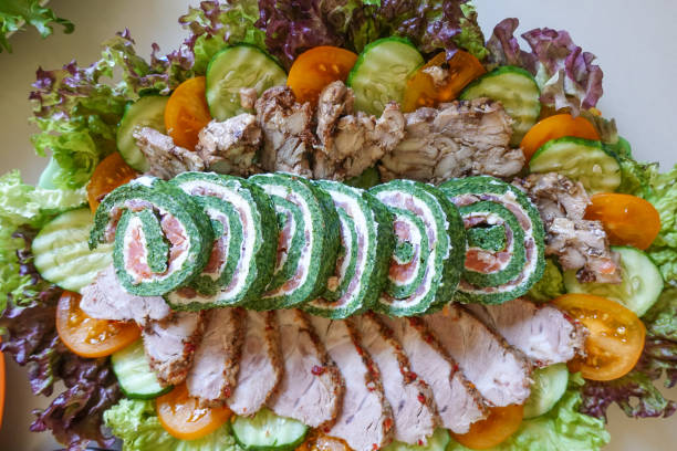 Roll of meat with various spices and herbs on a wooden table