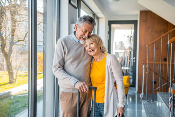 istock Senior couple affectionately standing in the hall with a suitcase 1146533965