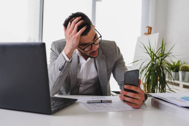 istock Businessman sitting on his office desk working on a computer and using smart phone 1146534300