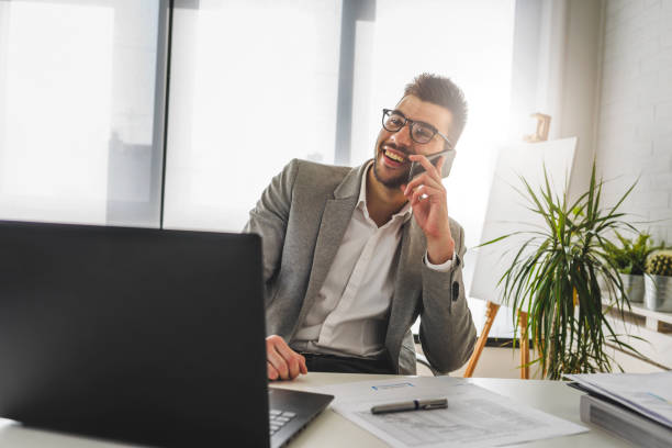 istock Businessman sitting on his office desk working on a computer and using smart phone 1146534415