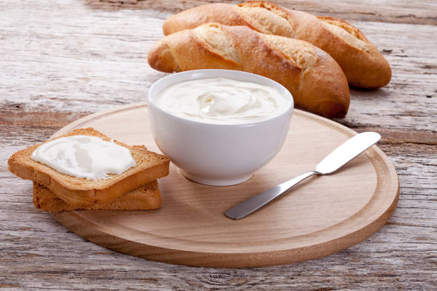 Cottage cheese pot with toast on wood background Breads, flours, eggs, breakfast table, sweet breads, butter, sliced bread, bread with butter, milk, curd, cheesecake, toast, toast with curd, fruit salad, coffee, juices, orange juice, fruits, Italian bread, French bread, Brazilian food. cream cheese photos stock pictures, royalty-free photos & images