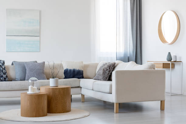 코너 소파와 커피 테이블과 우아한 거실 인테리어에 나무 프레임에 파란색과 흰색 추상 회화와 거울 - contemporary furniture 뉴스 사진 이미지