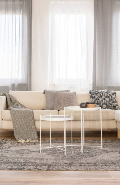istock Two white industrial coffee tables in front of comfortable couch with grey pillows and blanket 1146540921