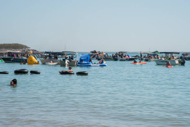 Darwin, Northern Territory, Australia-July 22,2018: Crowds enjoying the Timor Sea in nautical vessels, inflatables and kayaks at Mindil Beach in Darwin, Australia