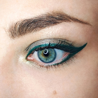 Blue eye gold green arrow eyeliner make-up eyebrow lash cosmetic swatch fashion macro photo.
