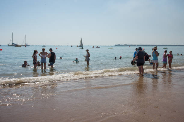 beach break: darwin, australia - women wading sun hat summer foto e immagini stock