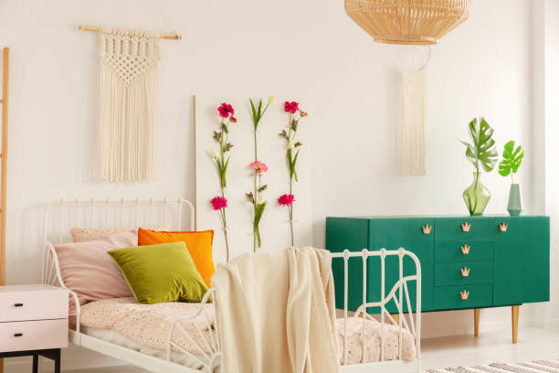 istock White handmade macrame above single metal bed with colorful pillows and doted bedding in fashionable boho bedroom interior with green cabinet and floral board 1146542313