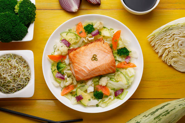 istock Salmon fillet Co vegetables on wood background 1146542781