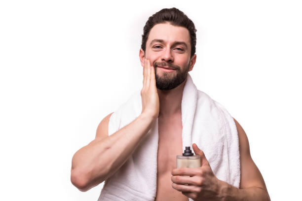 istock Handsome young man with muscular torso with perfume in hands isolated on white background 1146544483