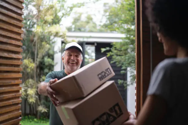 Courier delivering boxes to a young woman