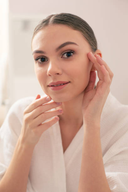 istock Beautiful woman smiling and touching her face with both hands 1146547958