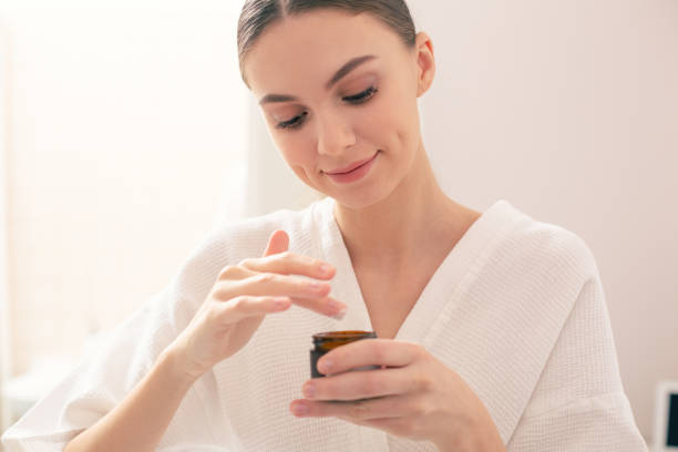 istock Calm lady smiling and taking cream from the little jar 1146548179