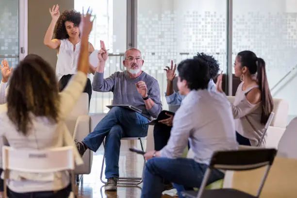 Mature male HOA president leads his neighbors in a vote during an HOA meeting.