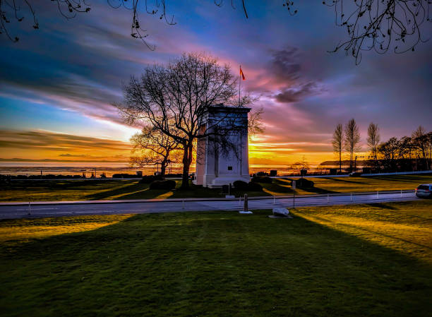 Beautiful Colorful Sunset the Sun Sets Over Trees and the Peace Arch at the Border Crossing Beautiful Colorful Sunset the Sun Sets Over Trees and the Peace Arch at the Border Crossing blaine washington stock pictures, royalty-free photos & images