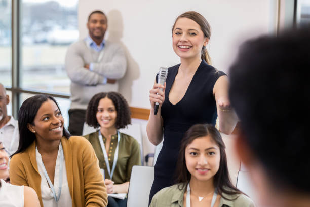 istock Mid adult Caucasian woman introduces speaker 1146553440