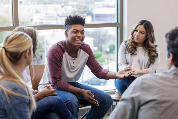 African American teen shares problem with diverse group A teen boy finally gets the courage to share about his problem with the therapy group. group therapy photos stock pictures, royalty-free photos & images