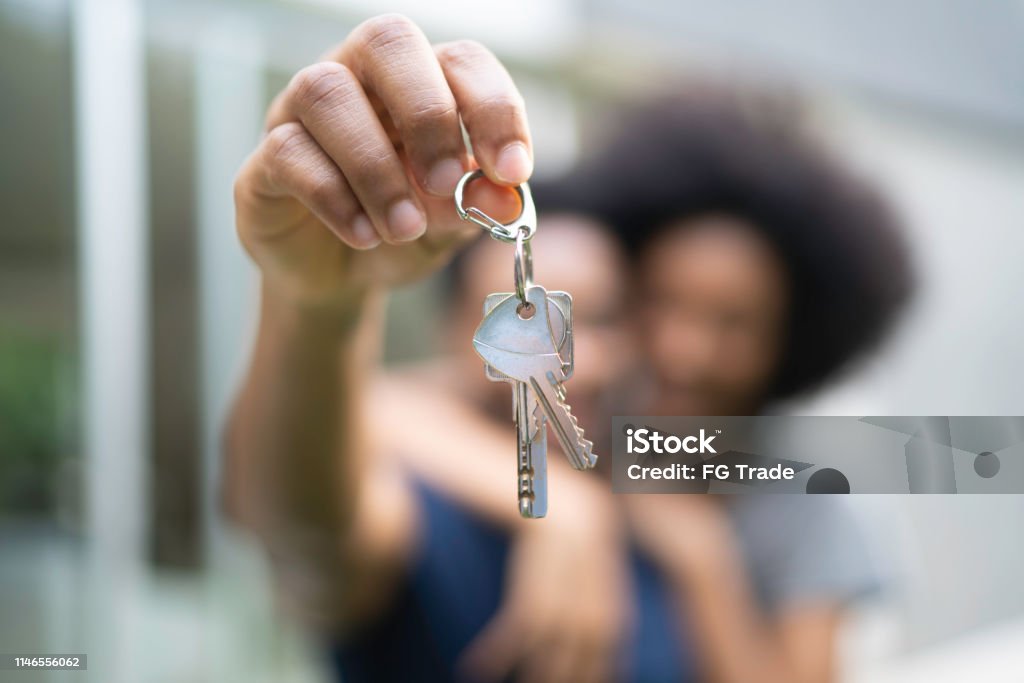 Young couple in front of a house, holding keys of their new home - Royalty-free Proprietário de Casa Foto de stock