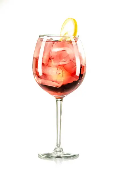 Photo of red drink with ice cubes and lemon on white background, isolated